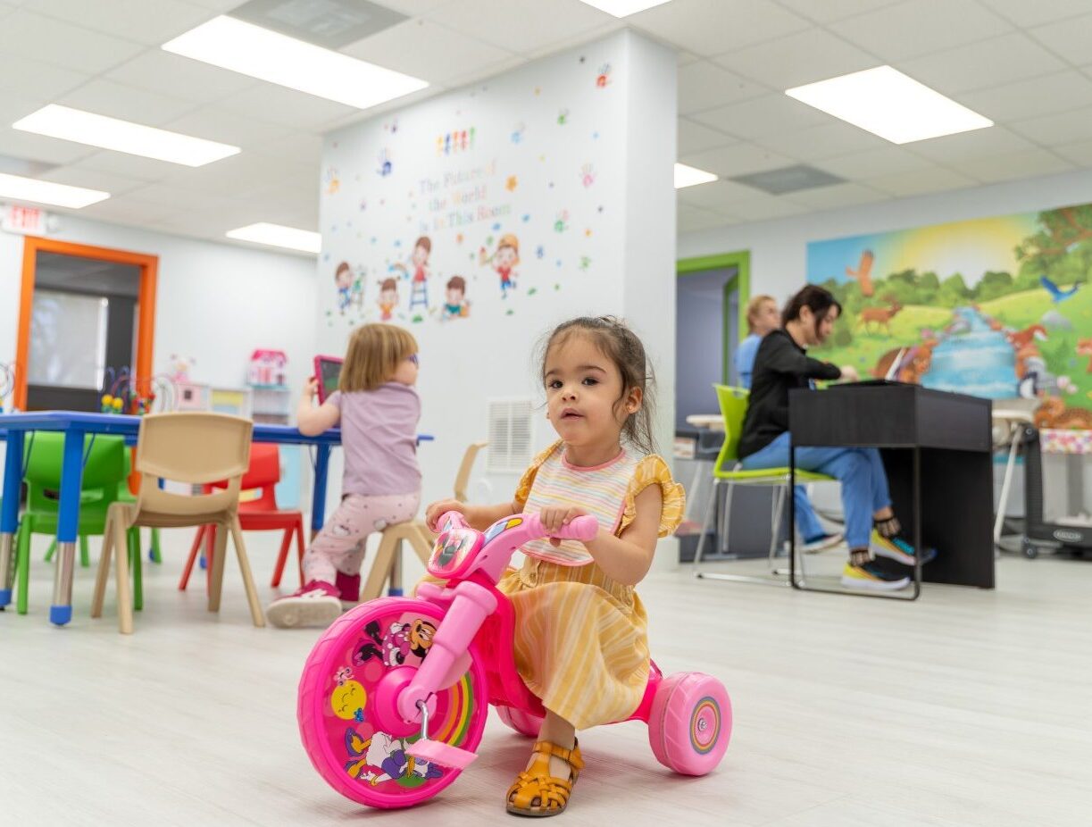 Child happily smiling at the camera during a fun activity at Peek A Boo Pediatric Care, Hollywood, FL.