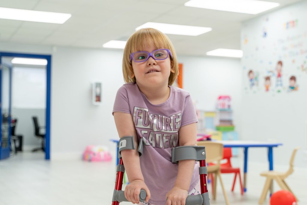 Close-up of a child smiling joyfully at the camera at Peek A Boo Pediatric Care, Hollywood, FL.