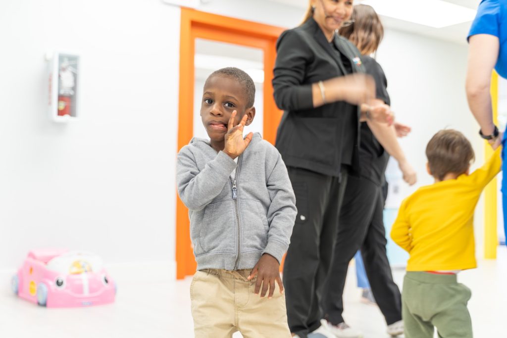 Happy child with a wide, grinning expression, smiling at the camera at Peek A Boo Pediatric Care.