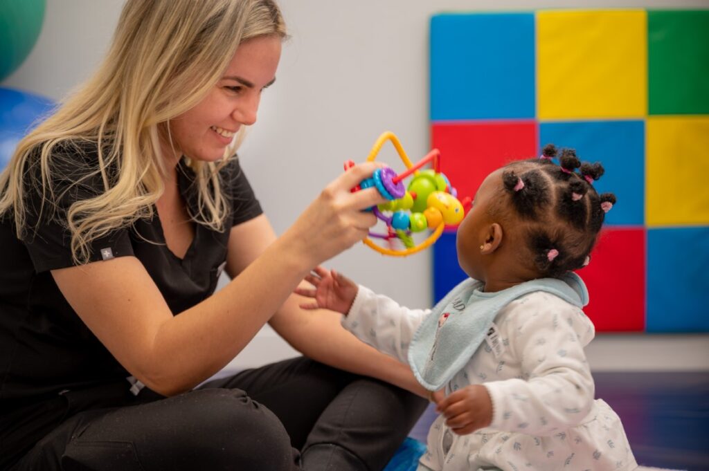 Child smiling and playing with a nurse after arriving at Peek A Boo Pediatric Care in Hollywood, FL