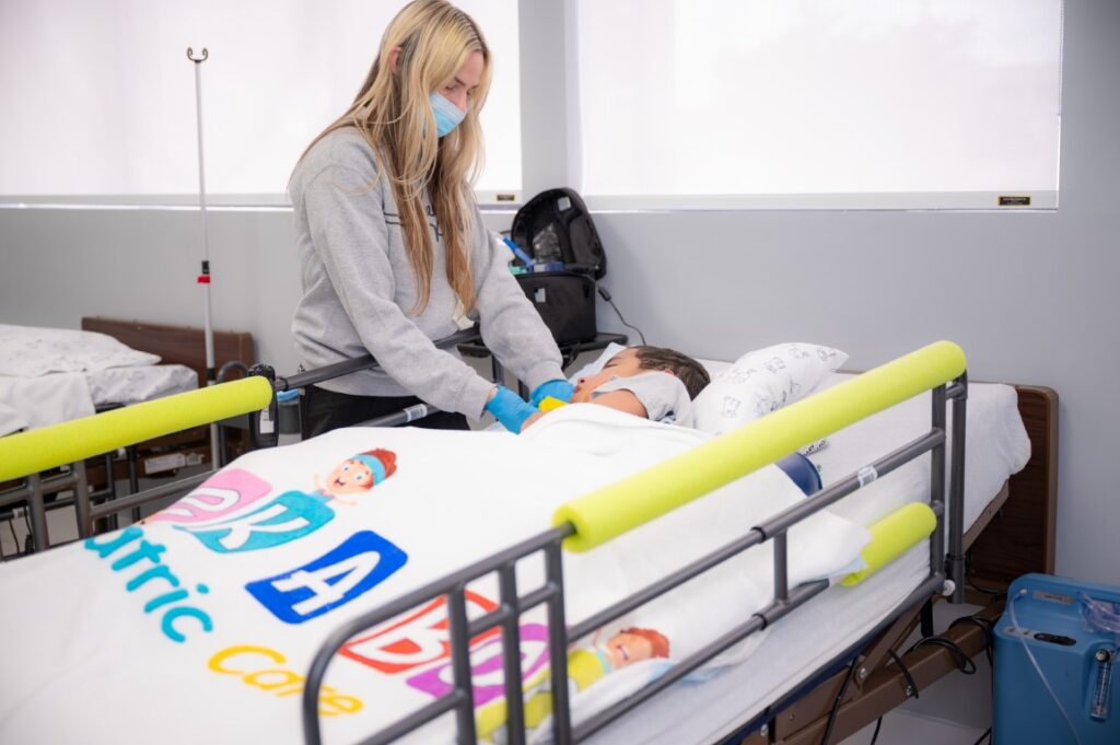 Nurse providing comforting one-on-one care to a child during treatment at Peek A Boo Pediatric Care in Hollywood, FL