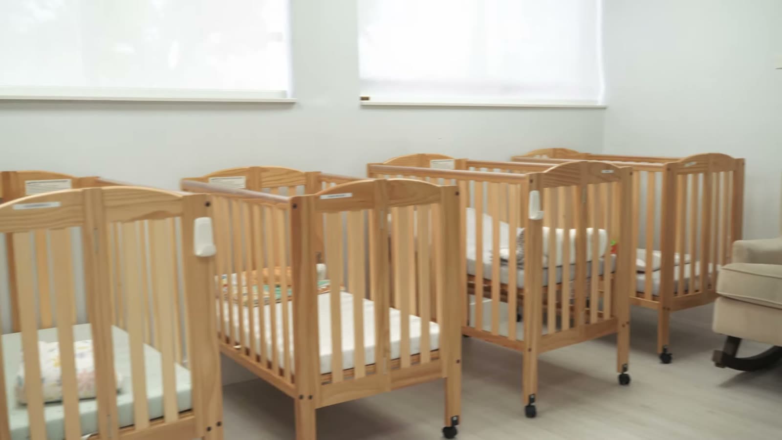 A row of wooden cribs in the infant room at Peek A Boo PPEC