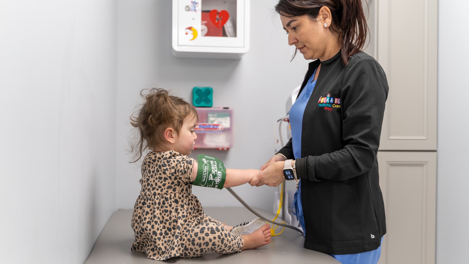 Nurse checking a young child's blood pressure during the morning assessment at Peek A Boo Pediatric Care in Hollywood, FL